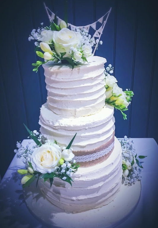Three tier white roses wedding cake